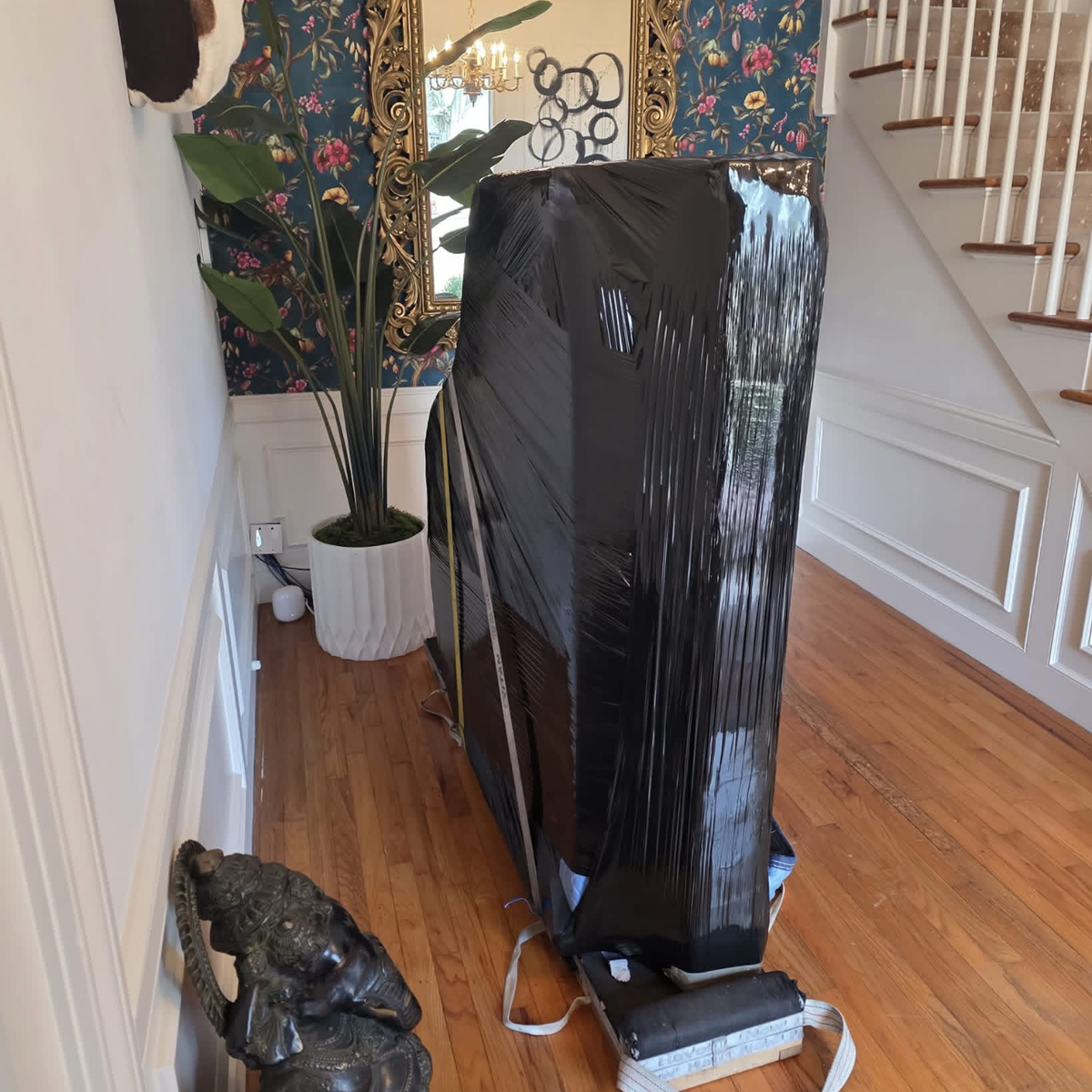 Carefully wrapped piano in elegant foyer